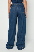Jeans con occhielli