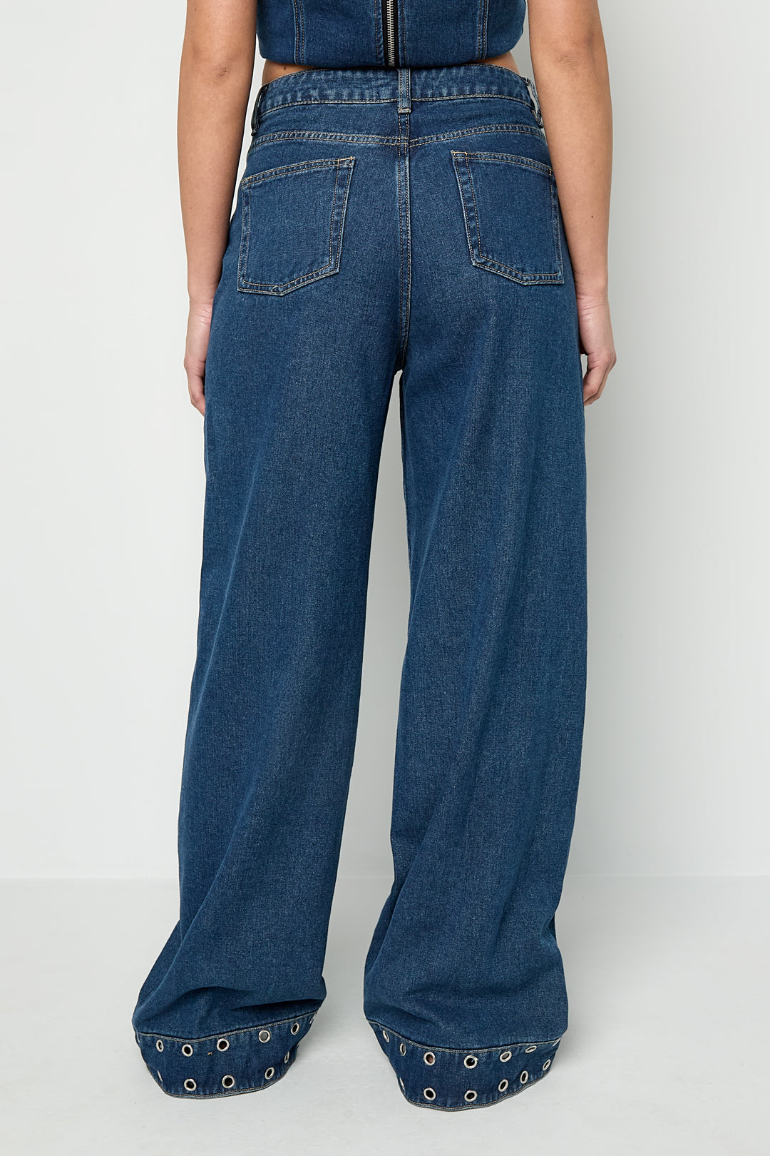 Jeans con occhielli