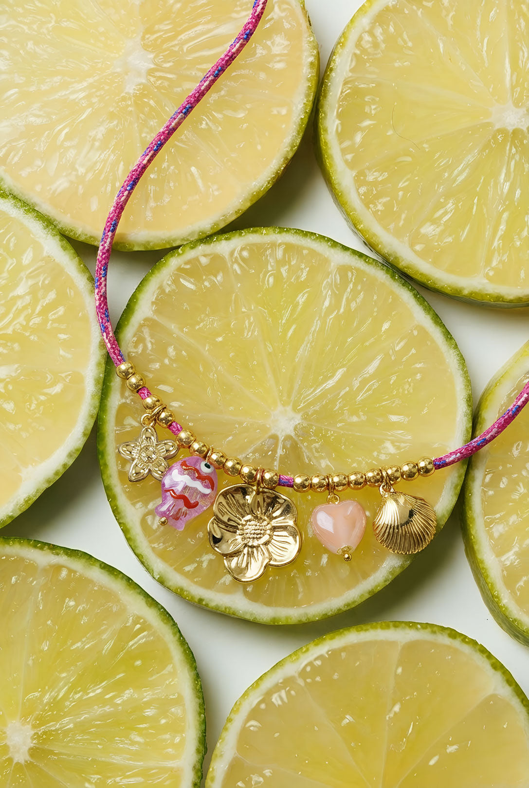 Collana con cordino colorato e vari ciondoli tra cui un ciondolo a forma di pesce.
