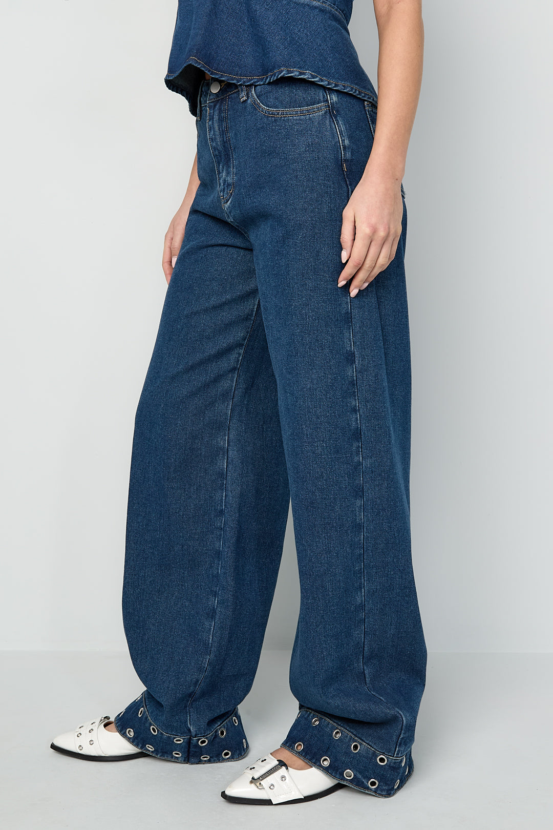 Jeans con occhielli