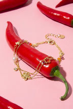 Braccialetto con ciondoli a forma di stella e fiore, perle, pietre e perline.